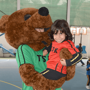 Child being cuddled by a mascot